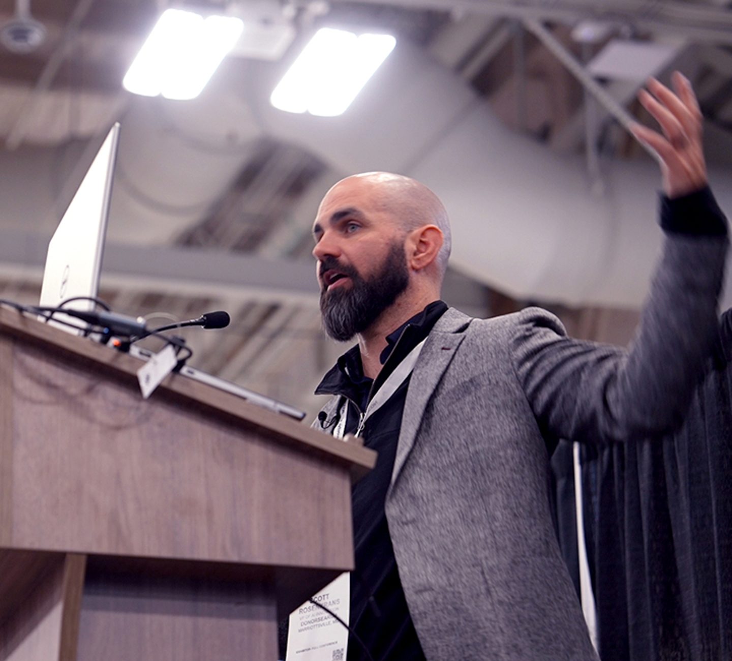 Scott Rosenkrans speaking at a conference podium.